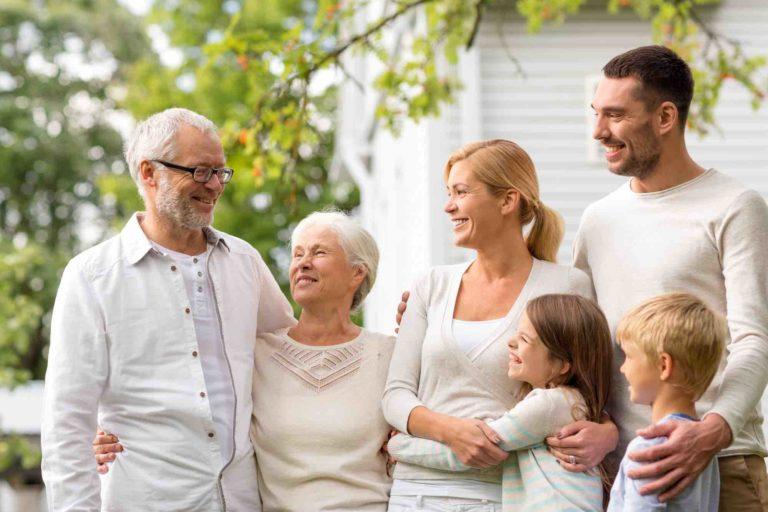 3 Generationen Familie steht vorm Haus